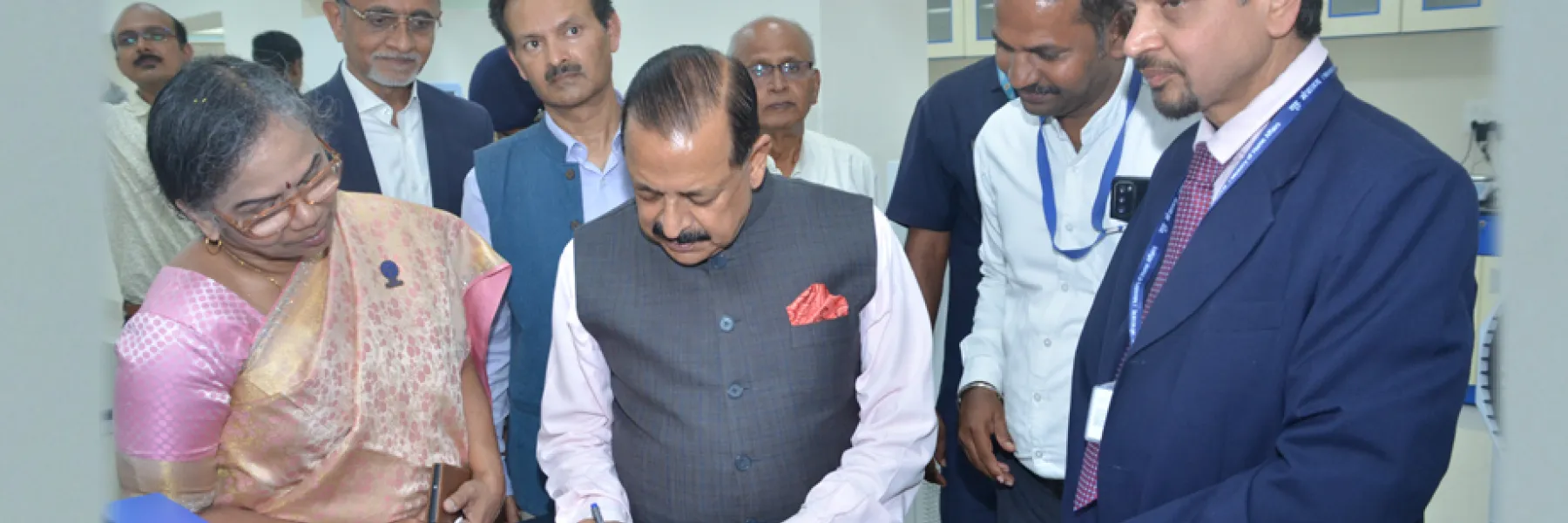 Dr. Jitendra Singh signing the visitors' book at a CSIR-CFTRI laboratory, watched by scientists and officials